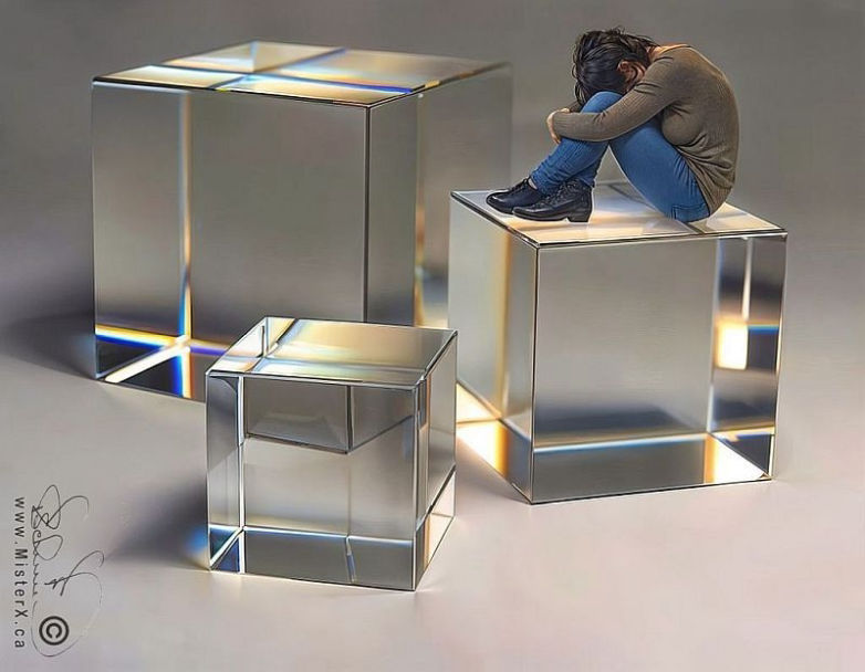 A woman sits upon one of three clear crystal cubes with her head buried between her knees.